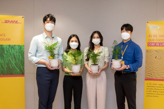 DHL코리아 직원들이 반려식물을 들고 기념촬영을 하고 있는 모습. <DHL코리아 제공>